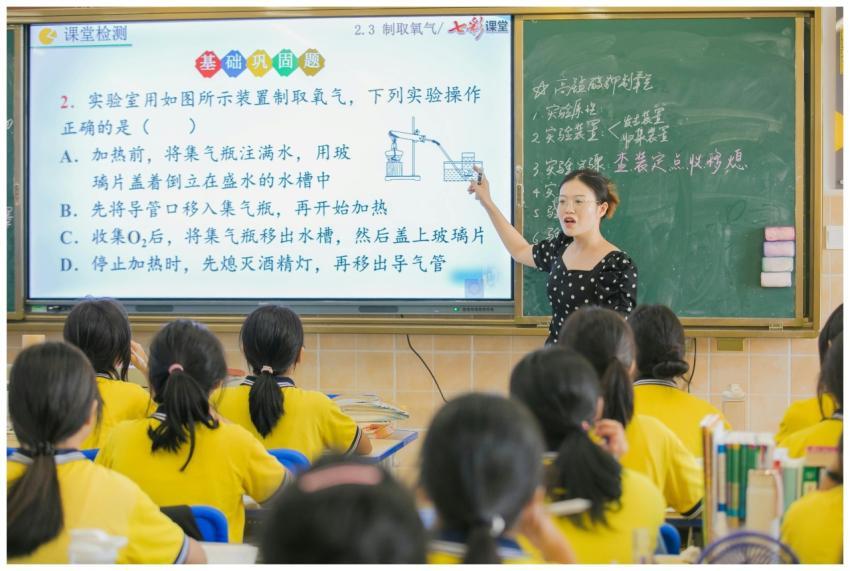 A teacher instructs students in a chemistry class,
