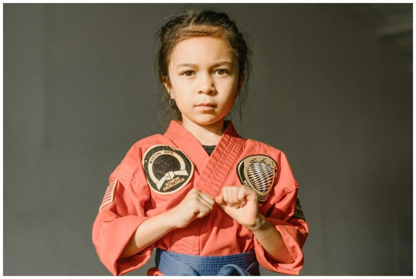 Confident child in a red dobok preparing for marti