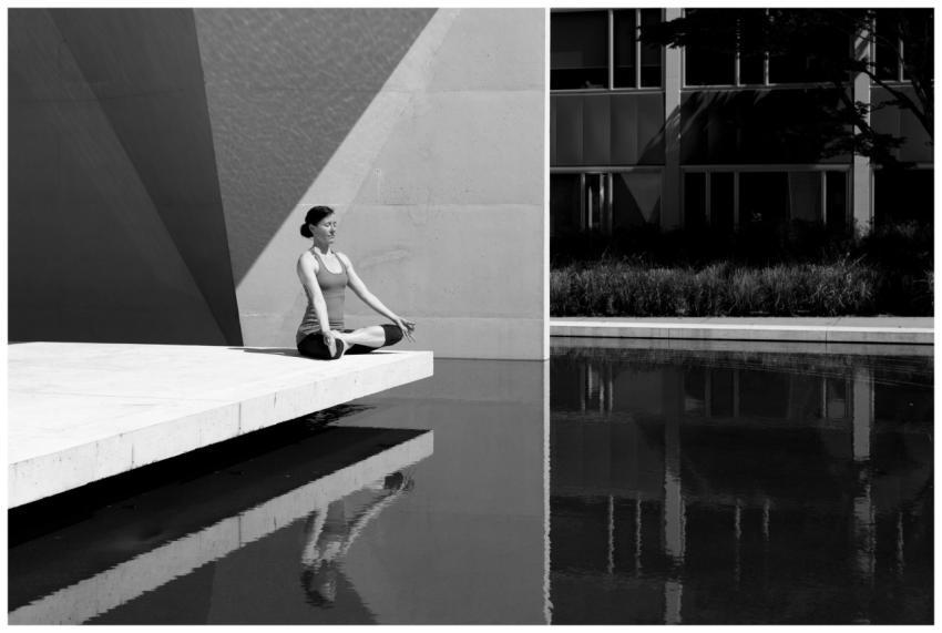 A woman meditating by a poolside, reflecting tranq
