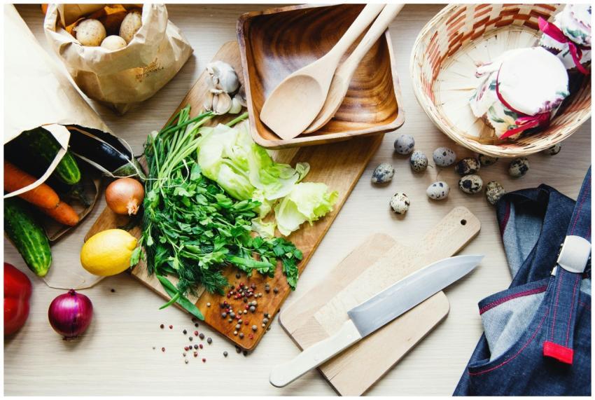 Top view of fresh vegetables, herbs, and kitchenwa