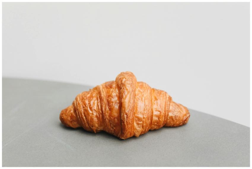 A delicious golden croissant photographed on a min