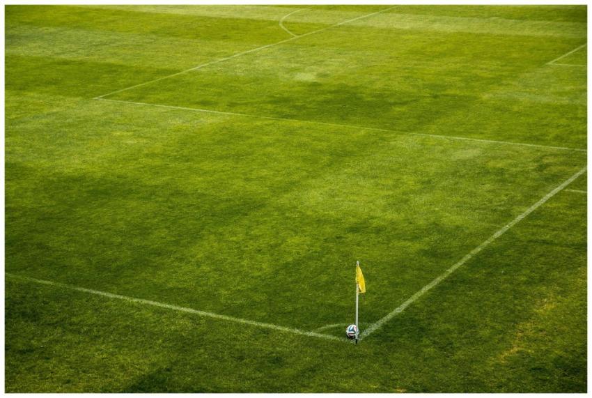 A vibrant green soccer field corner with a yellow