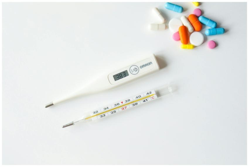 Digital and glass thermometers with colorful pills
