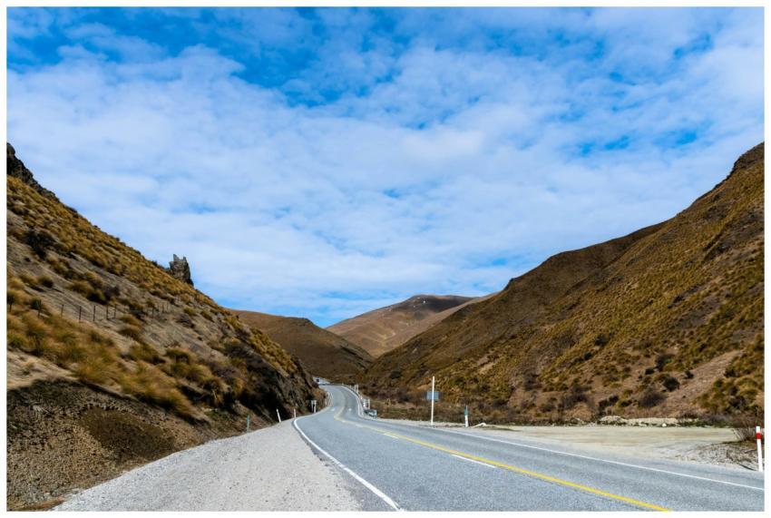 Peaceful curvy road through brown mountains under