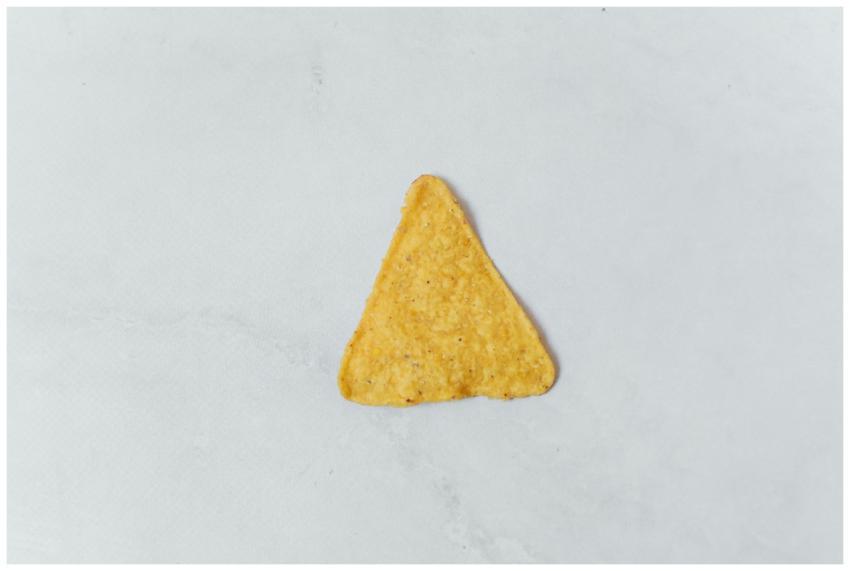 Close-up of a single crunchy tortilla chip on a mi