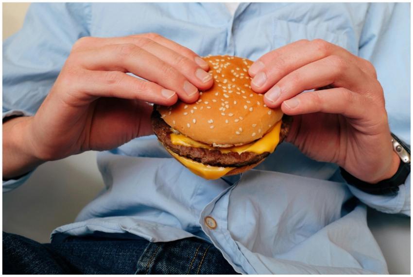 Hands holding a delicious cheeseburger, perfect fo
