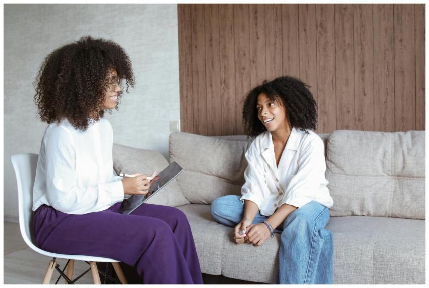 Two women in a friendly conversation on a sofa, sh