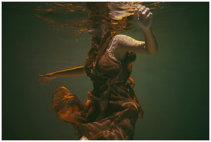 Elegant underwater photo of woman in flowing dress