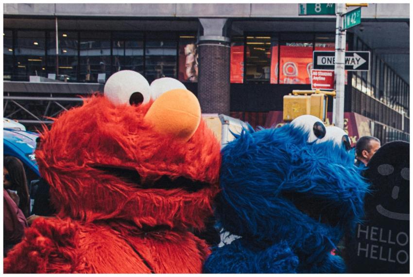 Two vibrant character costumes stand at a busy urb