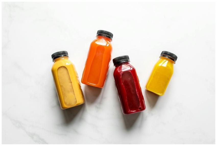 Colorful smoothies in bottles on a white backgroun
