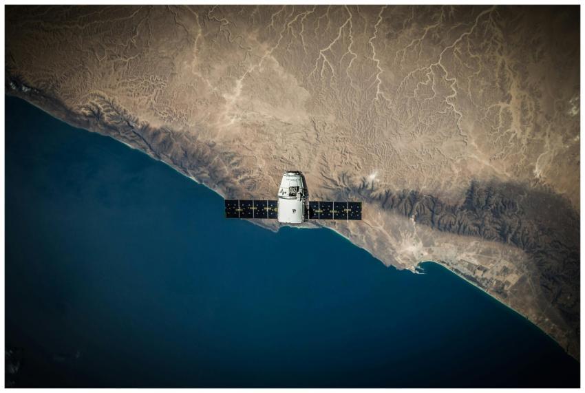 A satellite hovering above Earth's coastline, capt