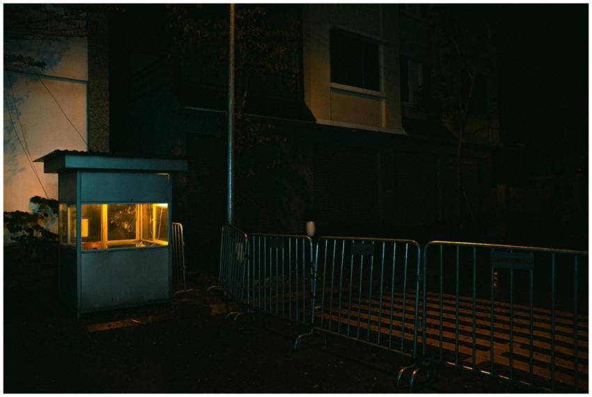Dimly lit street at night with a barricade and boo