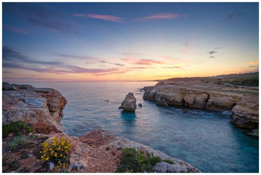 Beautiful sunset over the rocky shore of Ciutadell