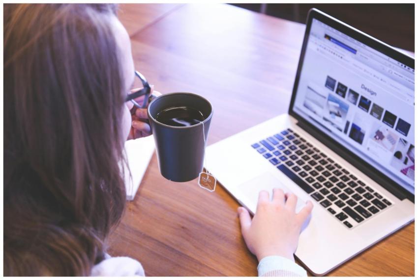 A woman enjoys coffee while browsing the web on a