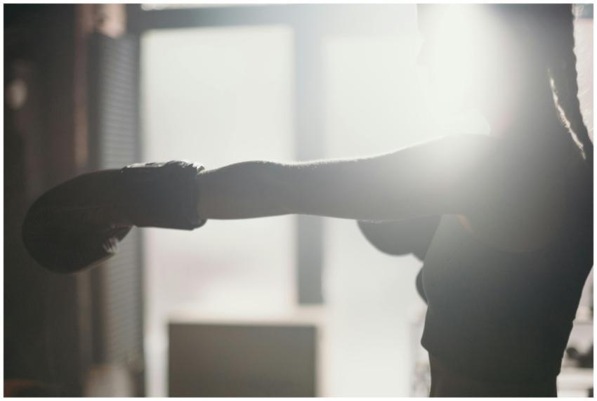 Silhouette of a female boxer throwing a punch in s