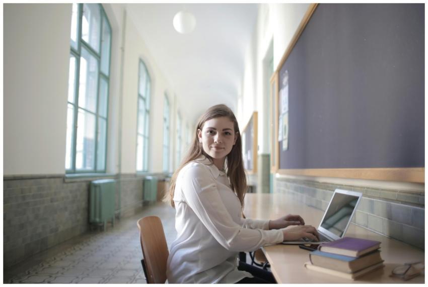Young woman using laptop in a bright university co