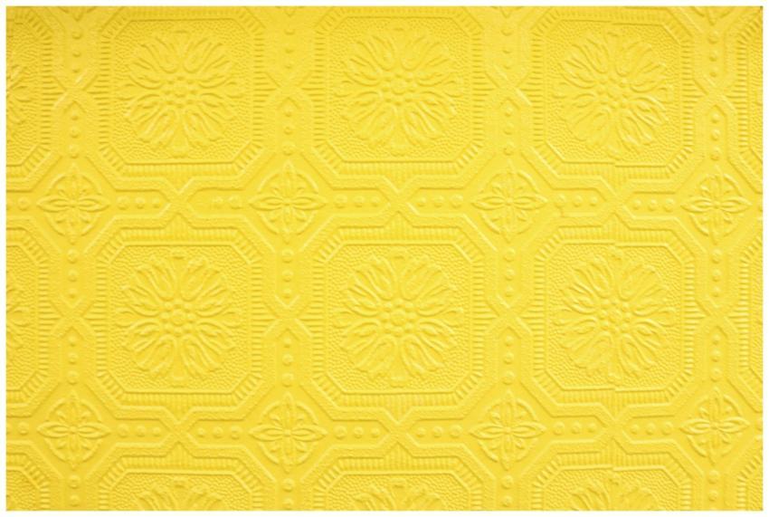Close-up of a decorative yellow embossed wallpaper