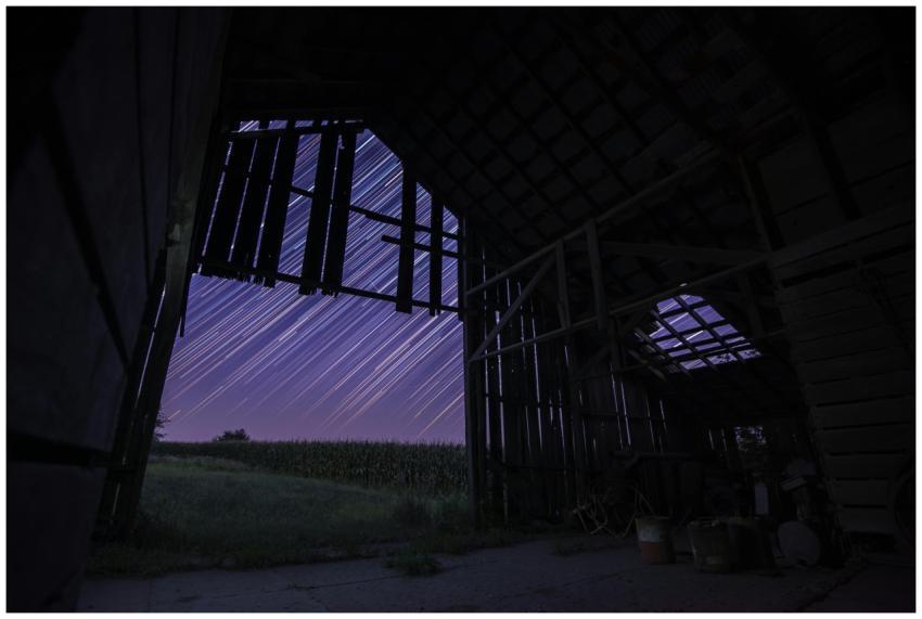 Long exposure of star trails through an abandoned