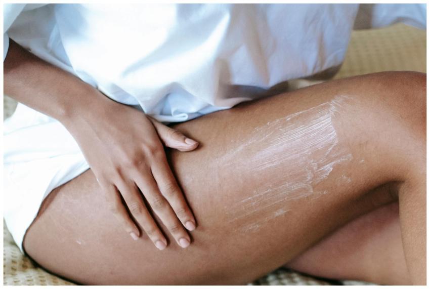 A woman gently applying moisturizing cream to her