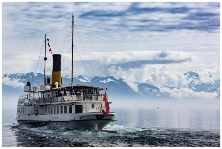 A luxury cruise ship sails on a misty lake with a