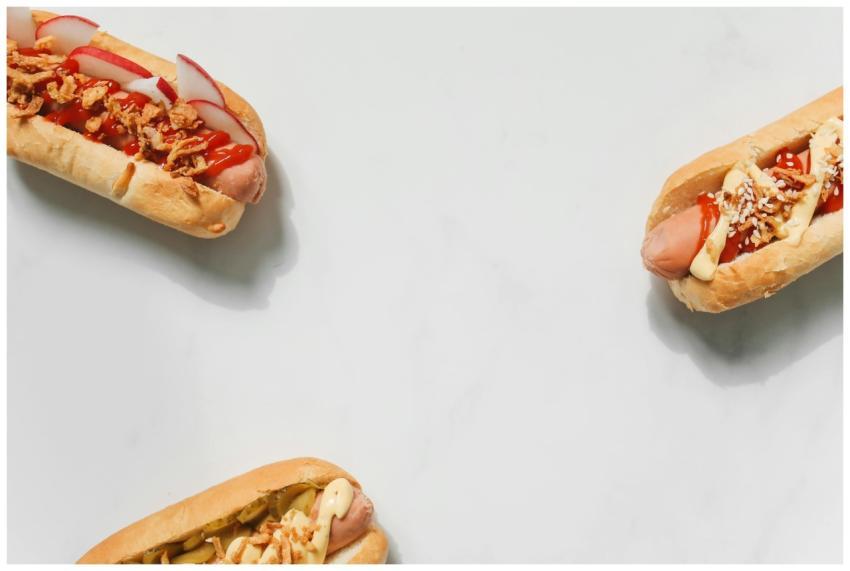 A flat lay of gourmet hot dogs with various toppin
