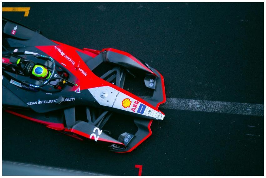 A dynamic top view of a Formula E car racing on a