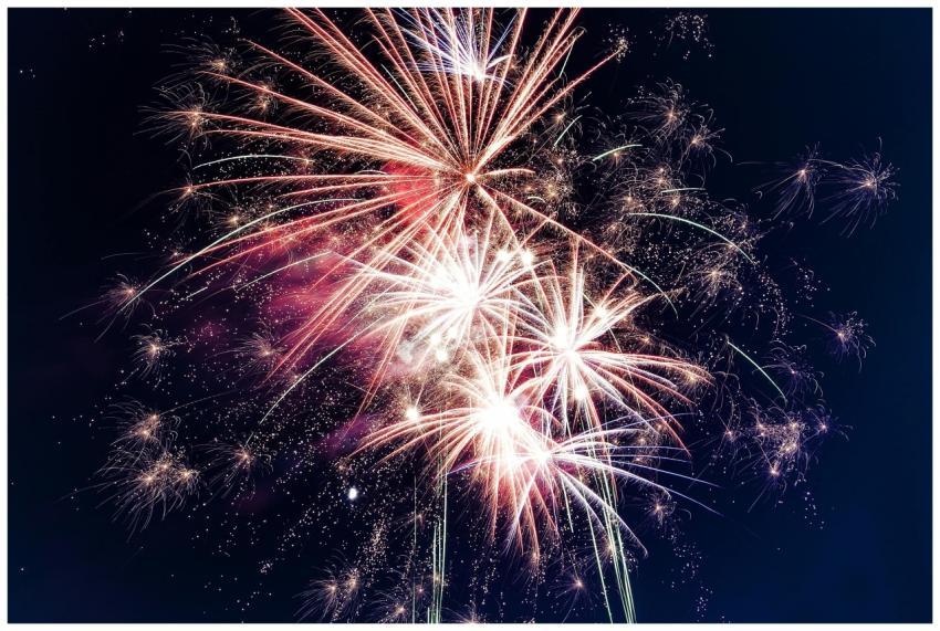 Colorful fireworks exploding in the night sky crea