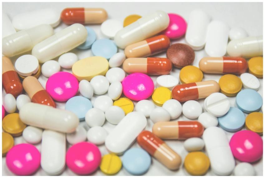 A mix of colorful pills and capsules scattered on