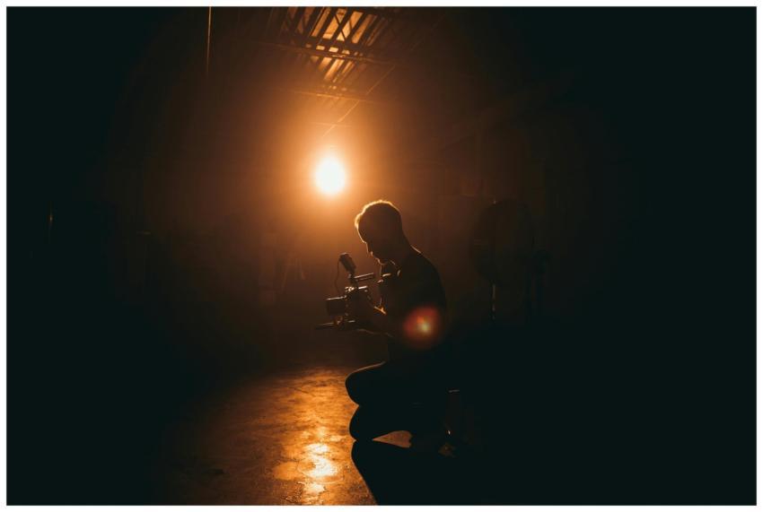 Silhouette of a cinematographer operating a camera