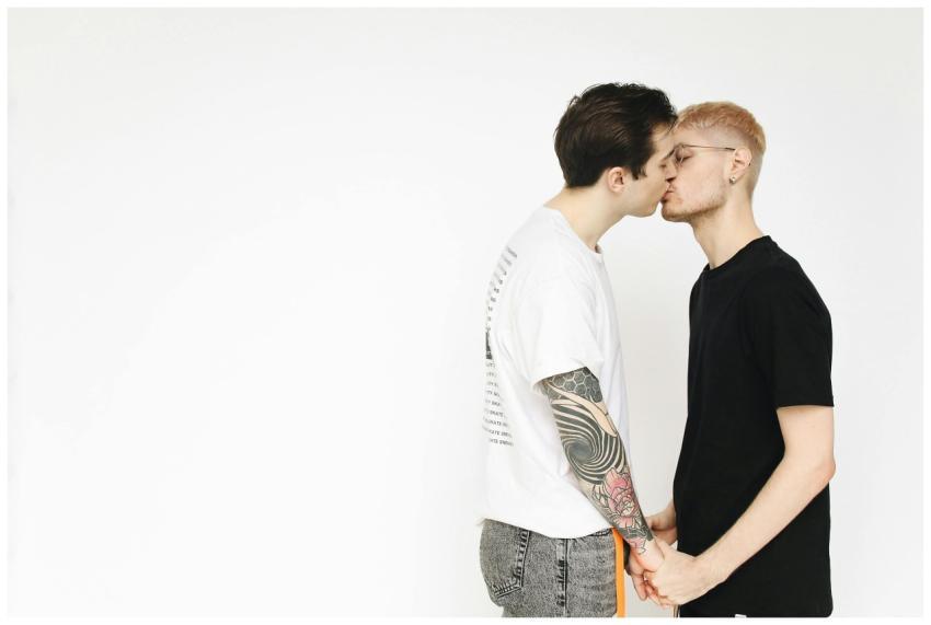 A tender moment captured of a gay couple kissing w