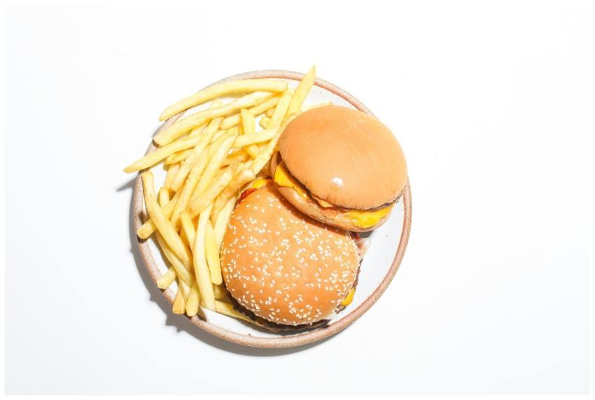 Two cheeseburgers and french fries served on a rou