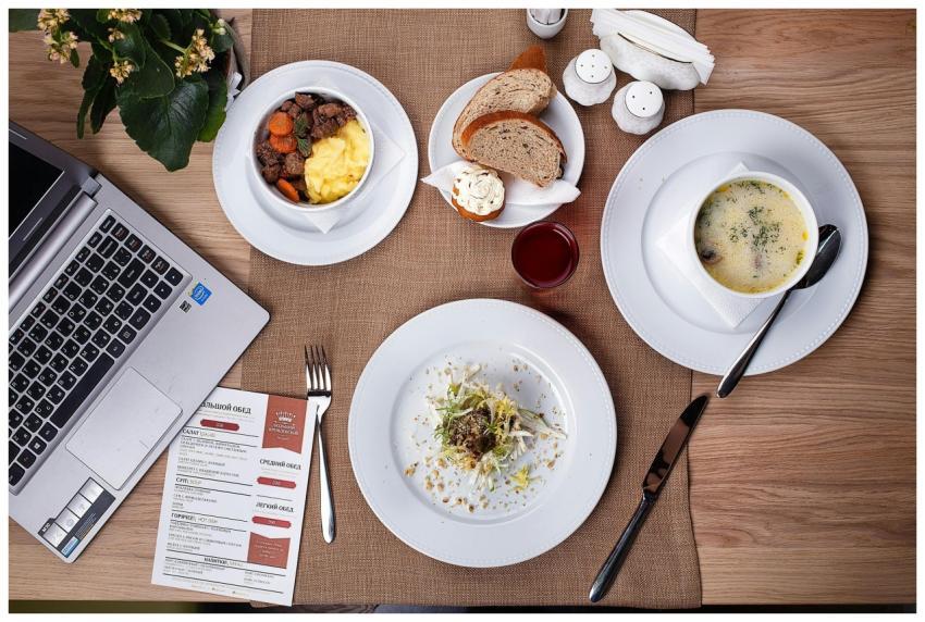 An overhead shot of a meal setup with laptop, show
