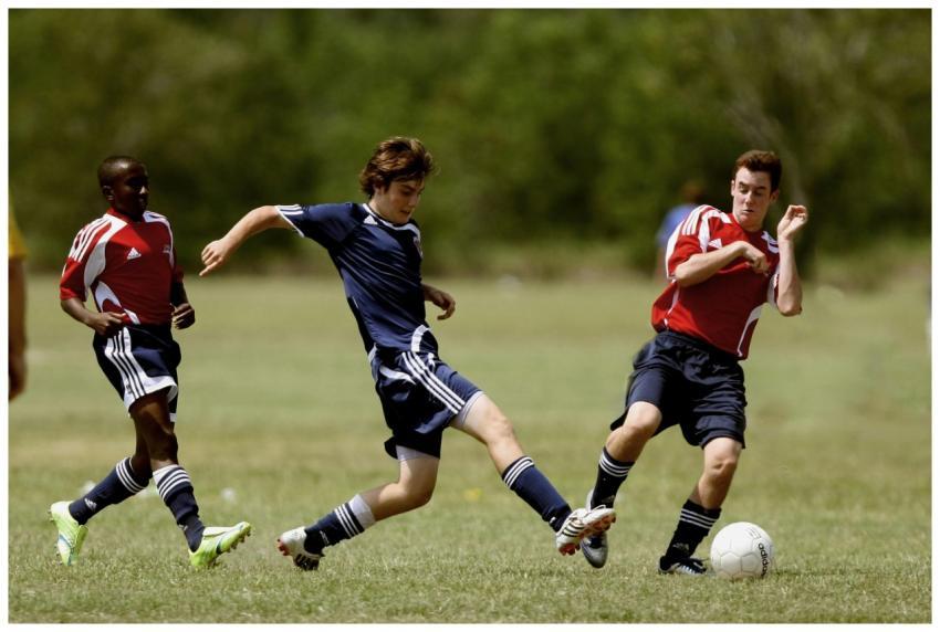Teenage soccer players in action during an outdoor
