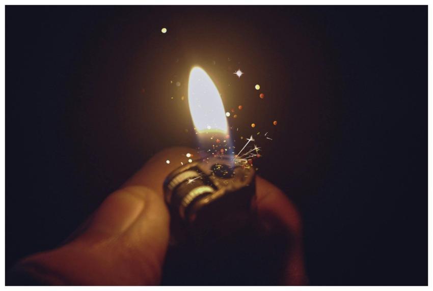 Intense close-up of a lighter igniting a bright fl