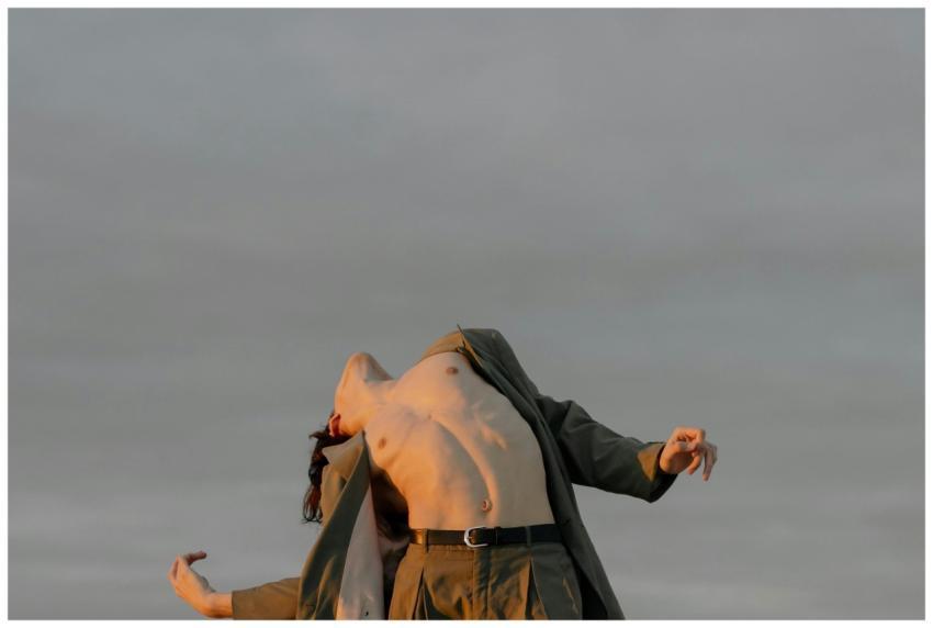 A male dancer performs dramatically against a clou