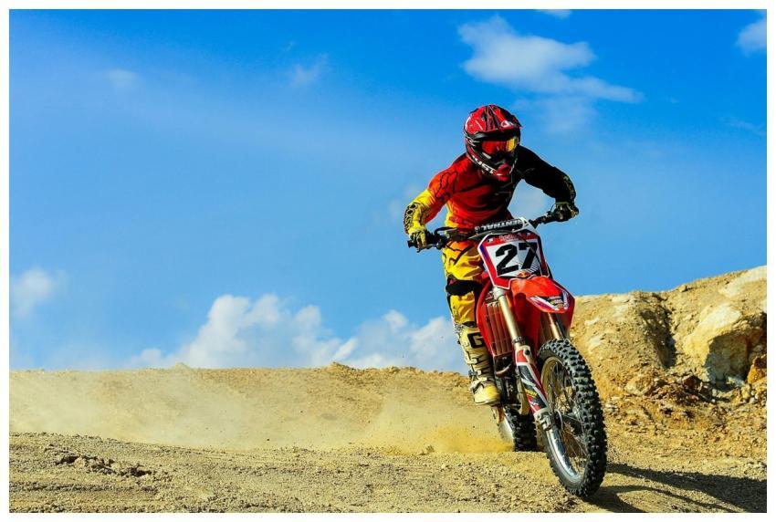 Motocross racer speeding through a dusty track und