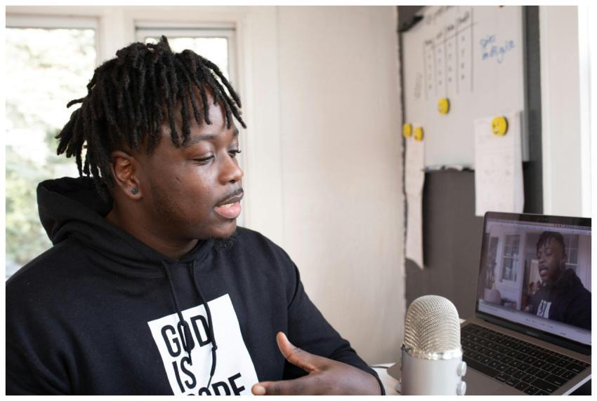 Man recording a podcast indoors with a laptop and