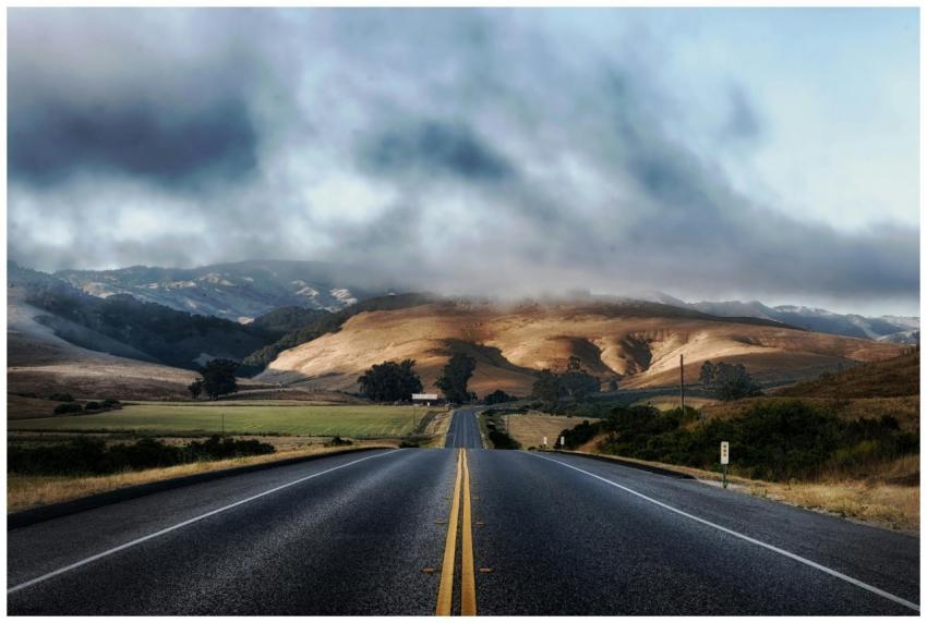 Dramatic sky over a deserted highway flanked by ro