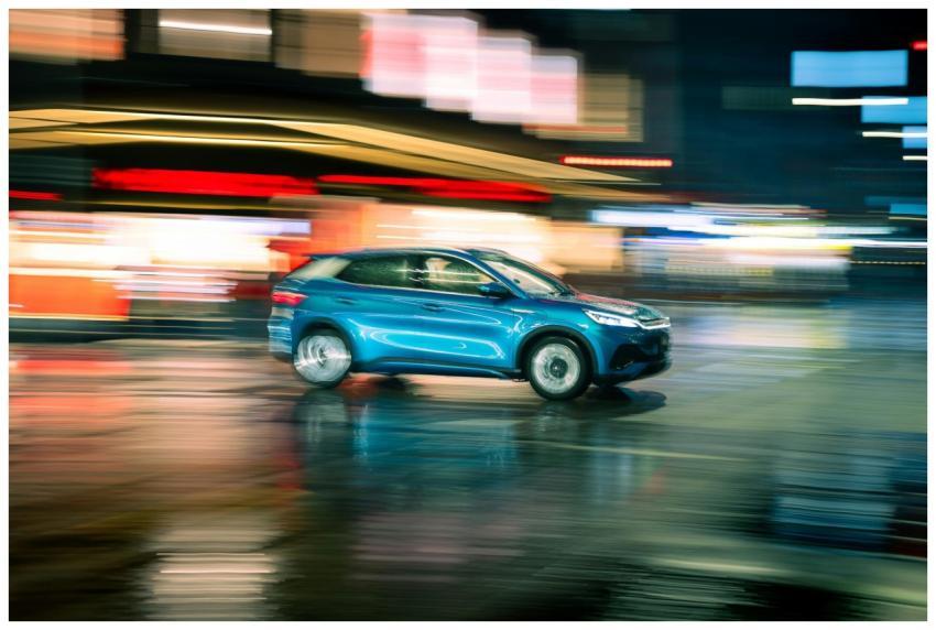 A vibrant night shot capturing a blue car in motio