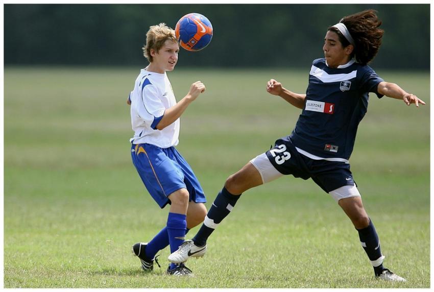 Two young soccer players compete intensely on the