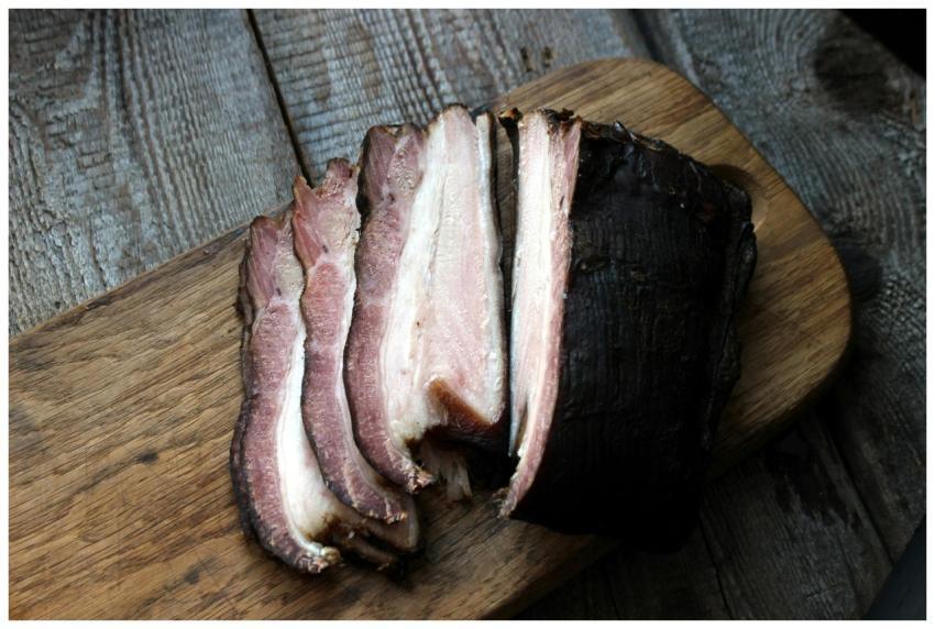 Close-up of smoked bacon slices on a rustic wooden