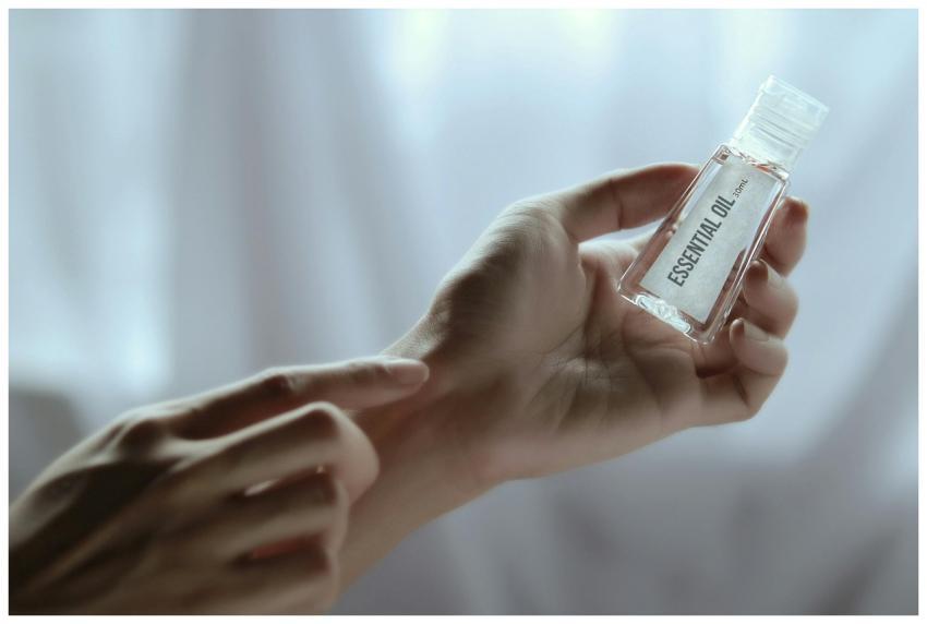 Close-up of a hand holding an essential oil bottle