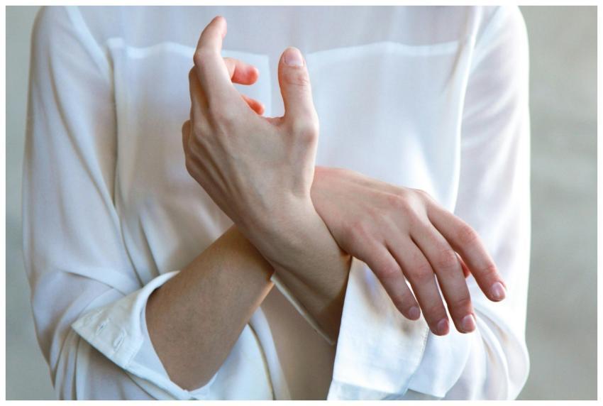 Elegant hands in a white shirt gently touching eac