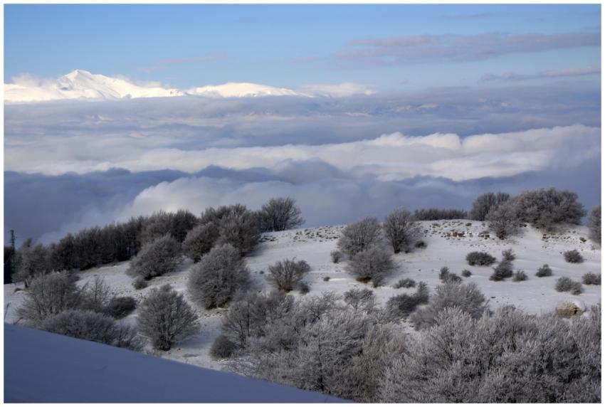 Captivating snowy mountain scene with clouds and t