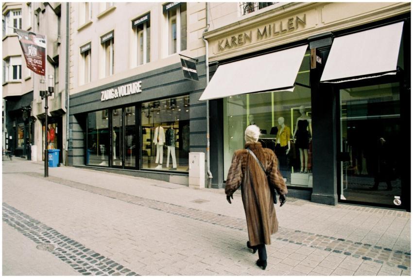 A person walks past stylish fashion boutiques on a