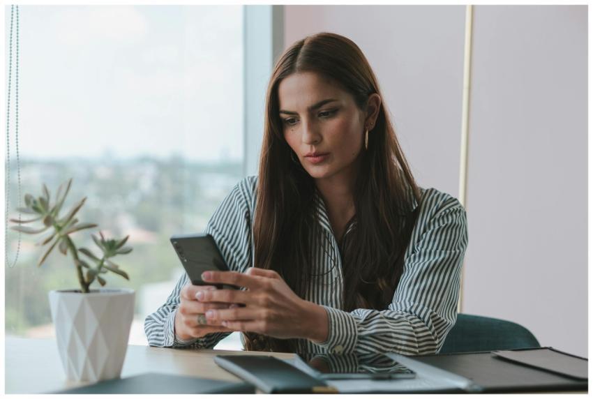 A businesswoman attentively using her smartphone a