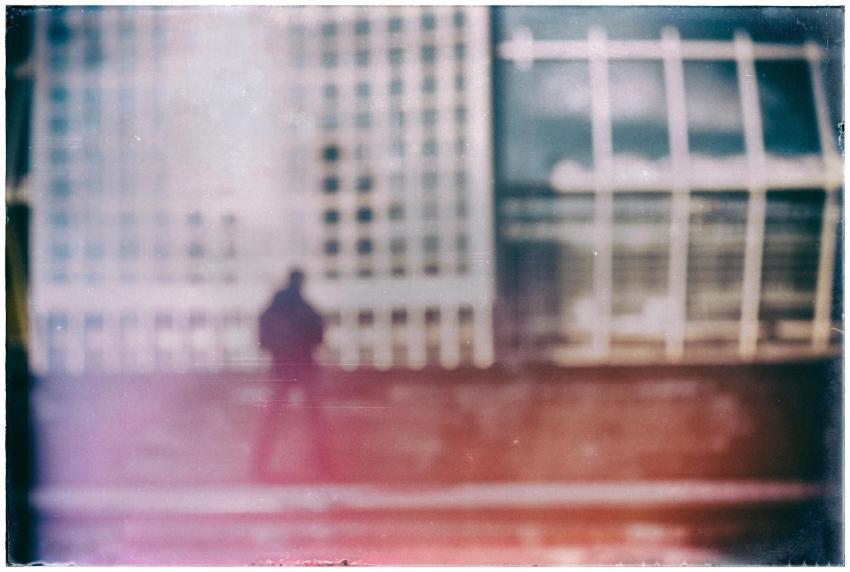 Blurred silhouette of a person against a glass bui