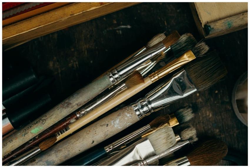 Close-up of various used paintbrushes in an artist