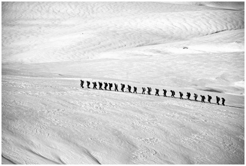 Silhouetted group hiking across a vast snowy lands