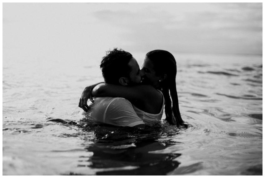 A romantic embrace and kiss in the ocean, captured